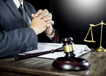 Lawyer with gavel & scales, offering asset protection & embezzlement defense consultation.