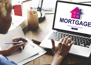 Person researching 'MORTGAGE' on a laptop, symbolizing home financing and potential fraud concerns.