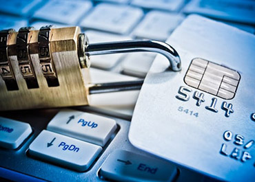Close-up of a combination lock securing a credit card on a keyboard, symbolizing data security.