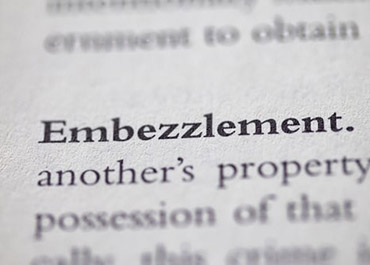 Close-up of text 'Embezzlement' in a legal document, emphasizing the term.
