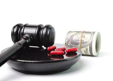 Gavel, red pills, and rolled dollar bills, symbolizing healthcare fraud and legal consequences.
