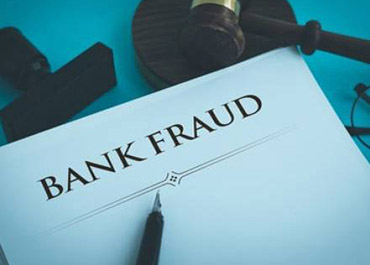 Pen on document titled 'BANK FRAUD' with gavel, symbolizing legal defense for fraud charges.