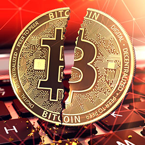 Split Bitcoin coin on keyboard, symbolizing cryptocurrency fraud legal issues.