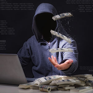 Hooded figure with money floating and stacked, binary code background, symbolizing cybercrime.