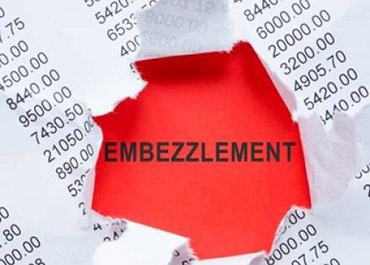 Torn financial document revealing 'EMBEZZLEMENT' on a red background, symbolizing hidden fraud.