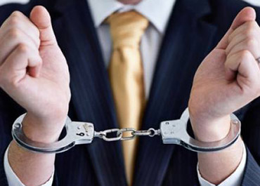 Businessman in suit with hands handcuffed, symbolizing a federal investigation or arrest.
