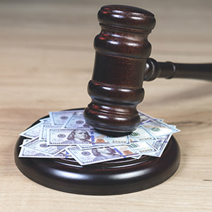 Judge's gavel resting on a pile of $100 bills, symbolizing Dallas cash seizure and money recovery law.